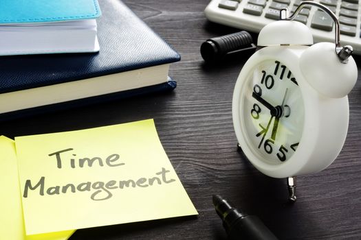 Time management written on a memo and alarm clock.