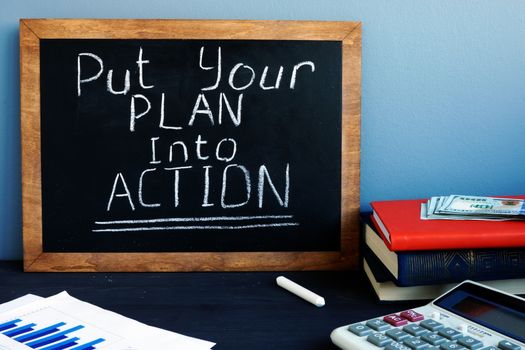 Put your plan into action handwritten in the office. Self motivation.