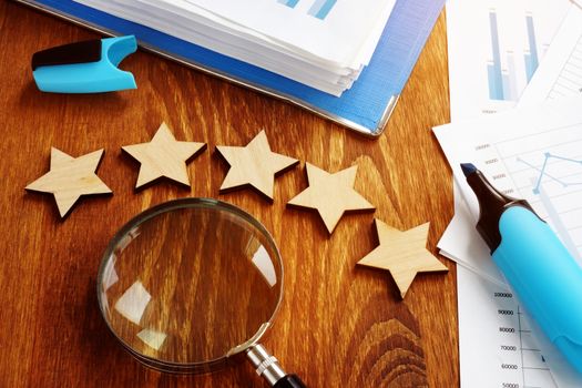Five stars and magnifying glass. Business appraisal and evaluation.
