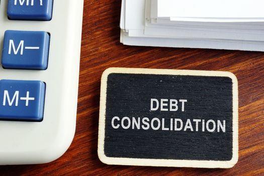 Debt consolidation loan. Nameplate with stack of documents.