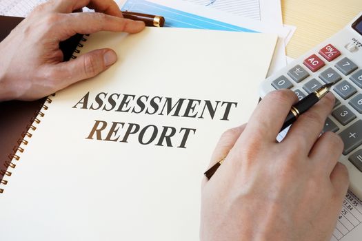 Document with title Assessment report on a desk.