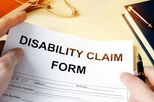 Man holding disability claim form for insurance.