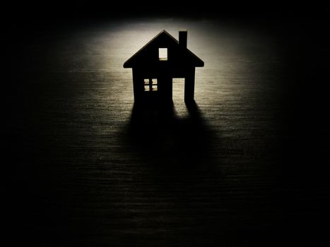 Model of house in the dark. Mortgage and real estate investment.