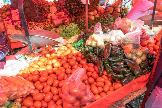 Woman buying some vegetables and fruits in a local mexican market