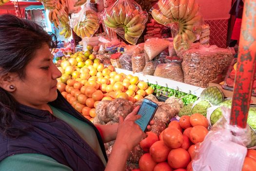 Woman buying some vegetables and fruits in a local mexican market