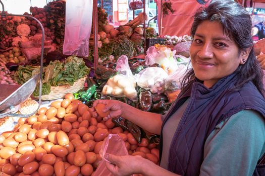 Woman buying some vegetables and fruits in a local mexican market