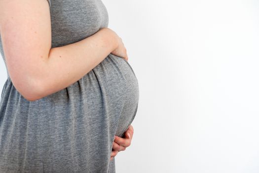 Pregnant woman caring and sharing love with her baby by touching her belly with hands