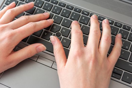 Woman working at home office hands on keyboard close up