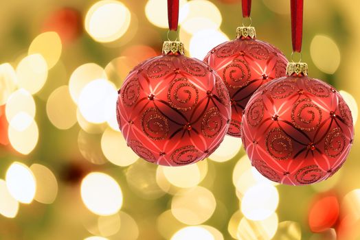 Beautiful Christmas decoration - red baubles on a background of blurred lights on a Christmas tree with bokeh effect.