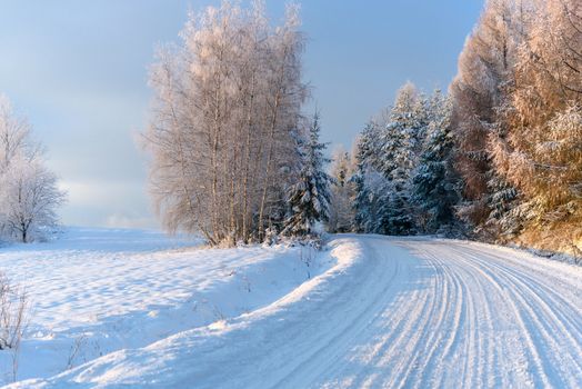 Winter landscape - snow covered mountain road on a cold and sunny morning