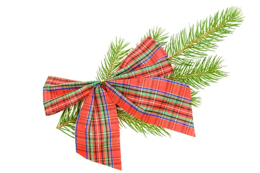 Christmas decorations concept - red checkered bow on a spruce twig on a white background in close-up