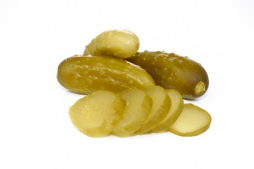 Group of tasty pickled cucumbers and sliced portions on a white background in close-up
