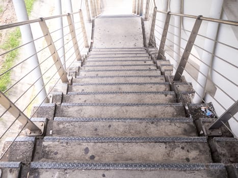 staircase for descending from footbridge. The concrete overpass for crossing the road.