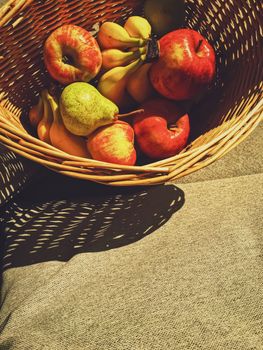 Organic apples, pears and bananas on rustic in a wicker basket, fruits farming and agriculture