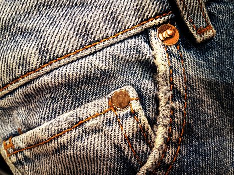 Old blue jeans details - front pocket and buckle loop in close-up