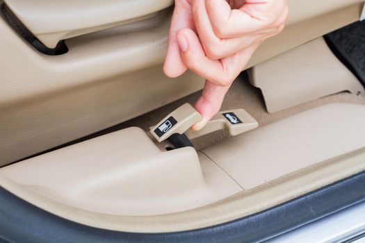 closeup hand pulling fuel door open button in a car.