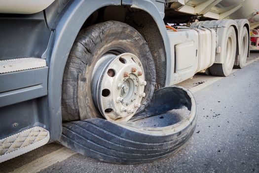 closeup damaged 18 wheeler semi truck burst tires by highway street