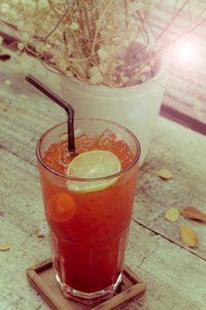 Summer lemon ice tea on the table with dry leaves. Vintage retro style