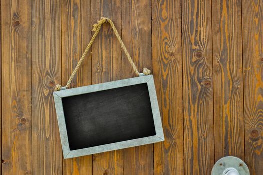 blank space on black chalk board with rope on wooden door of a coffee shop