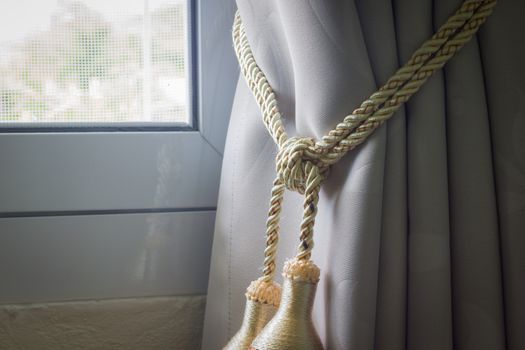 closeup curtains tassel with rope by the window on the left.