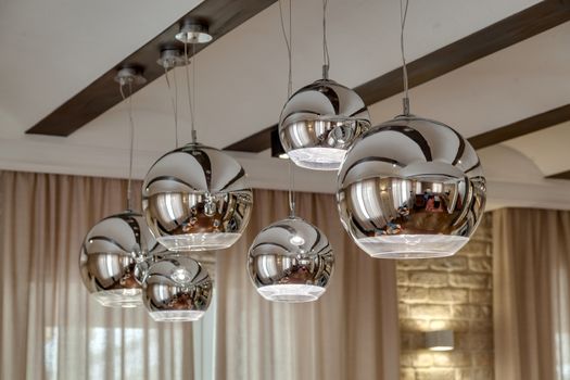 Modern chrome lamp on the ceiling in the room