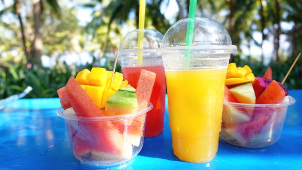 Citrus fruits and slices of exotic fruits on a blue wooden table - summertime