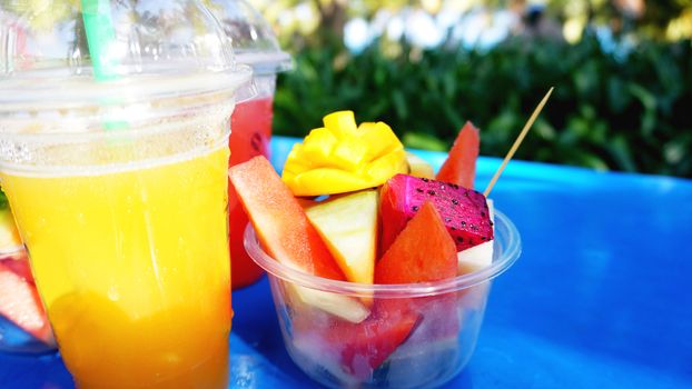 Citrus fruits and slices of exotic fruits on a blue wooden table - summertime