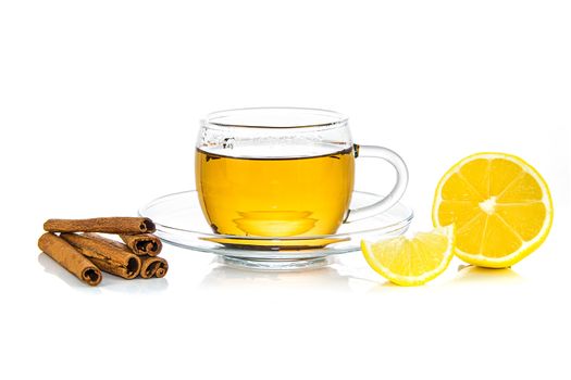 Concept image of a healing and warming drink - hot cup of tea with cinnamon and lemon isolated on a white background.