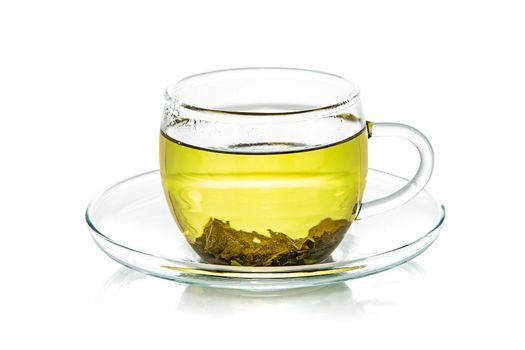 Transparent glass cup of natural green tea isolated on a white background in close-up 