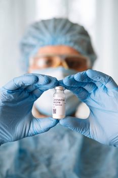 Coronavirus vaccine. Doctor with a vaccine. Hands holding a coronavirus vaccine ampoule, against Covid-19.