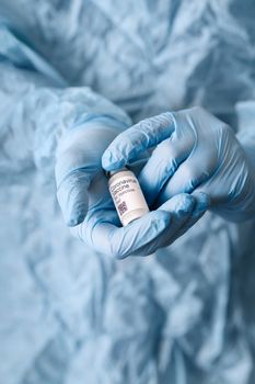 Coronavirus vaccine. Doctor with a vaccine. Hands holding a coronavirus vaccine ampoule, against Covid-19.