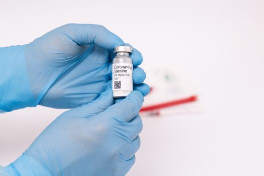 Coronavirus vaccine. Doctor with a vaccine. Hands holding a coronavirus vaccine ampoule, against Covid-19.