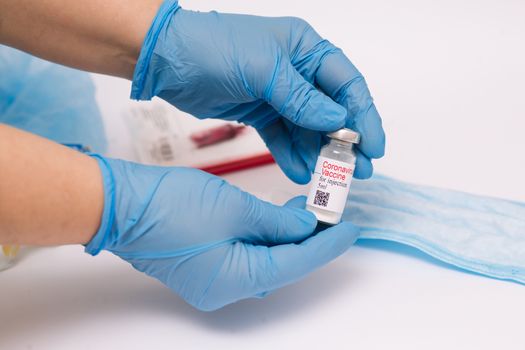 Coronavirus vaccine. Doctor with a vaccine. Hands holding a coronavirus vaccine ampoule, against Covid-19.