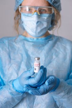 Coronavirus vaccine. Doctor with a vaccine. Nurse holding a coronavirus vaccine. Hands holding a coronavirus vaccine ampoule, against Covid-19.