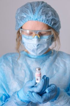 Coronavirus vaccine. Doctor with a vaccine. Nurse holding a coronavirus vaccine. Hands holding a coronavirus vaccine ampoule, against Covid-19.