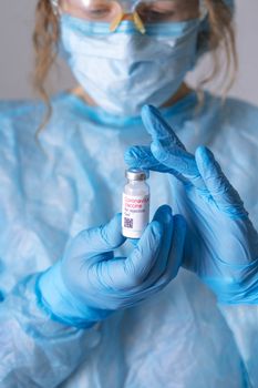 Coronavirus vaccine. Doctor with a vaccine. Nurse holding a coronavirus vaccine. Hands holding a coronavirus vaccine ampoule, against Covid-19.