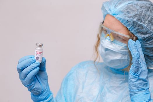 Coronavirus vaccine. Doctor with a vaccine. Nurse holding a coronavirus vaccine. Hands holding a coronavirus vaccine ampoule, against Covid-19.