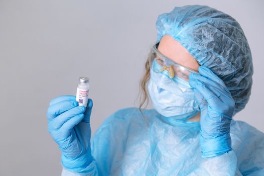 Coronavirus vaccine. Doctor with a vaccine. Nurse holding a coronavirus vaccine. Hands holding a coronavirus vaccine ampoule, against Covid-19.