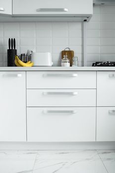 White lacquered kitchen facades on a comfortable kitchen. Modern white kitchen clean interior design