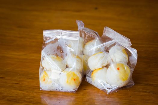 Traditional Chinese cake in plastic bag on wooden background