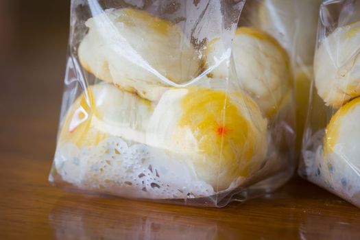 Traditional Chinese cake in plastic bag on wooden background