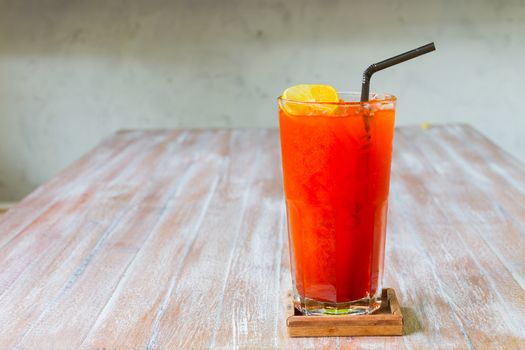 Ice tea glasss with lemon on wooden table background.