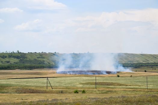 Fire in the field where hay was grown. burning dry grass