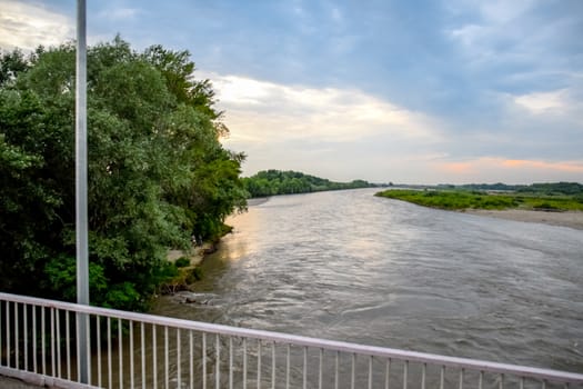 Passing over the bridge over the river. The landscape of the river, the surface and the trees of the river's waterplain.