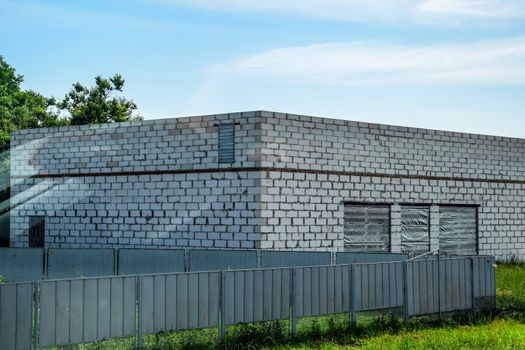 The building is made of white foam block and a gray metal fence.