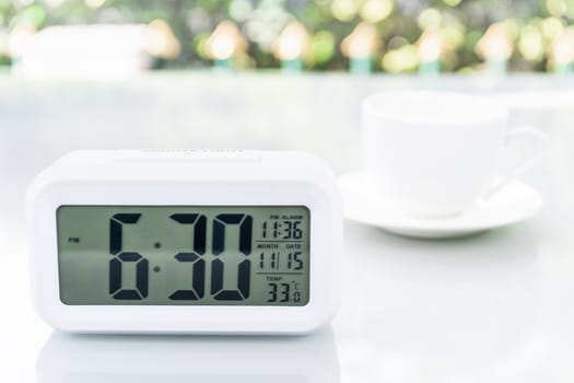 Close up Digital clock on table at office with coffee cup