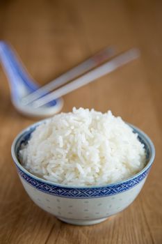 a bowl of white rice on wooden background