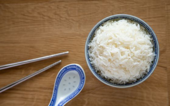 a bowl of white rice on wooden background