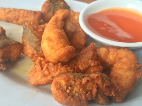 Horizontal photo of closeup fried fish with chili sauce. Shallow depth of field.