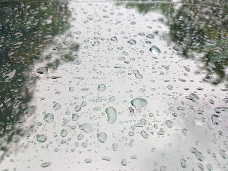 Rain drops in front of the car window with reflection